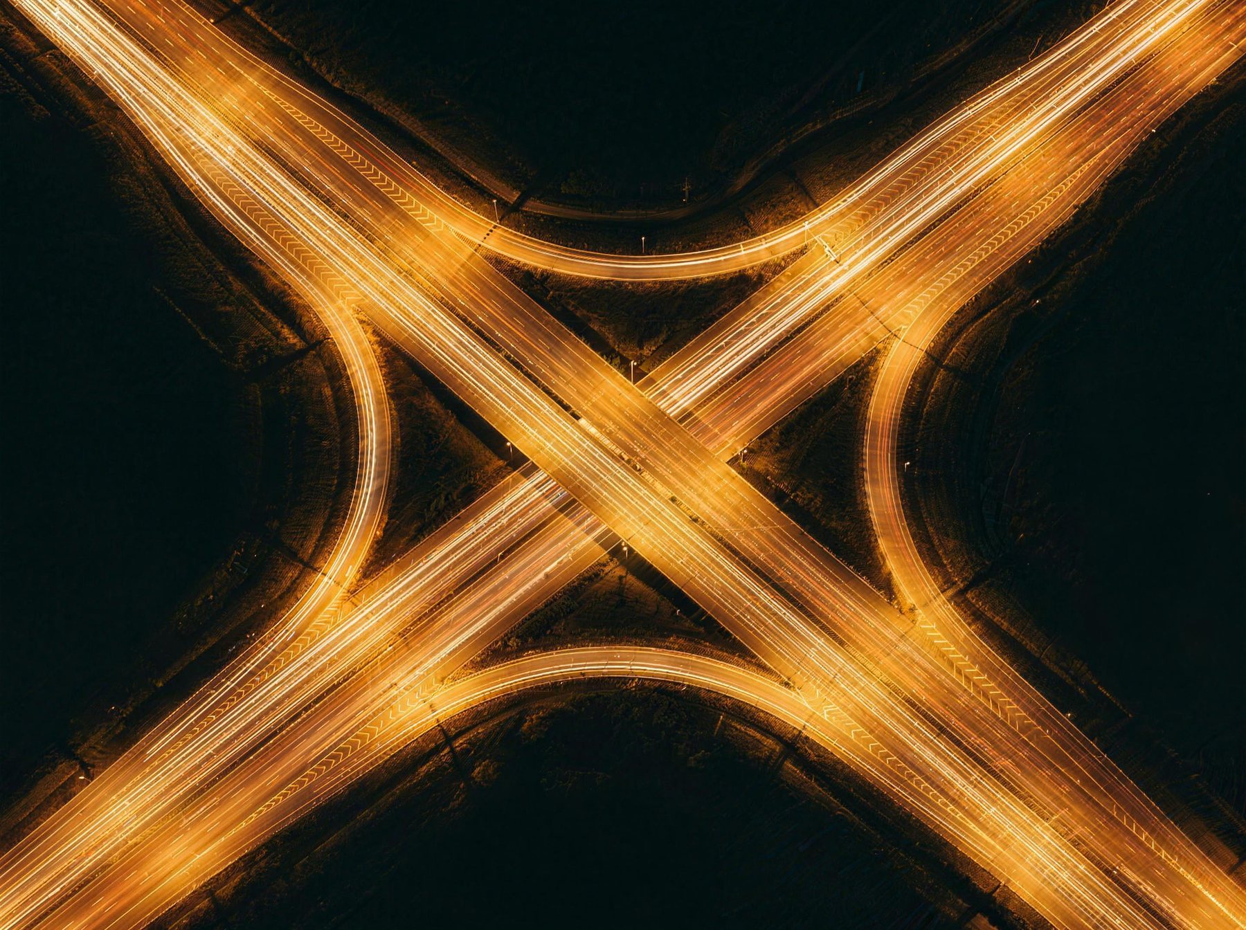 Nocny węzeł autostradowy z góry ze smugami świateł samochodów